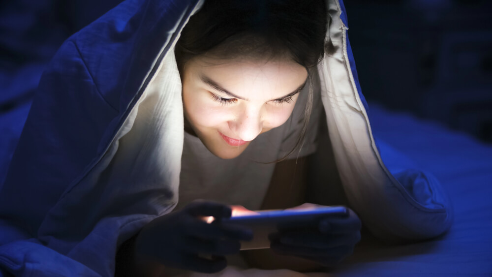 teenager playing video game at bedtime