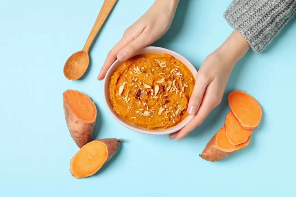 A small bowl of mashed sweet potato and finely shredded chicken, a nutritious and easy-to-eat meal idea for a 10-month-old baby.