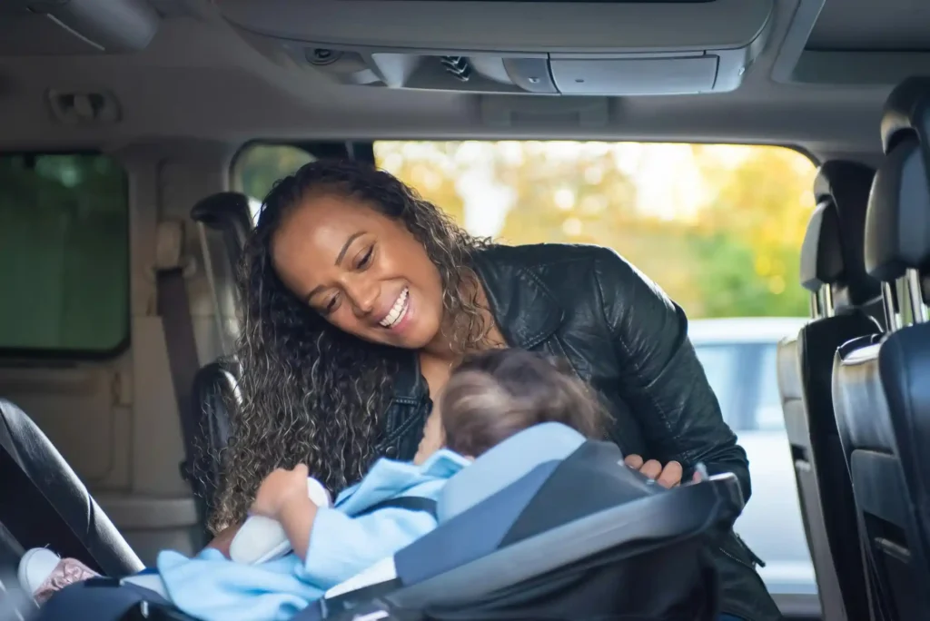 A happy mom and her baby in the car seat